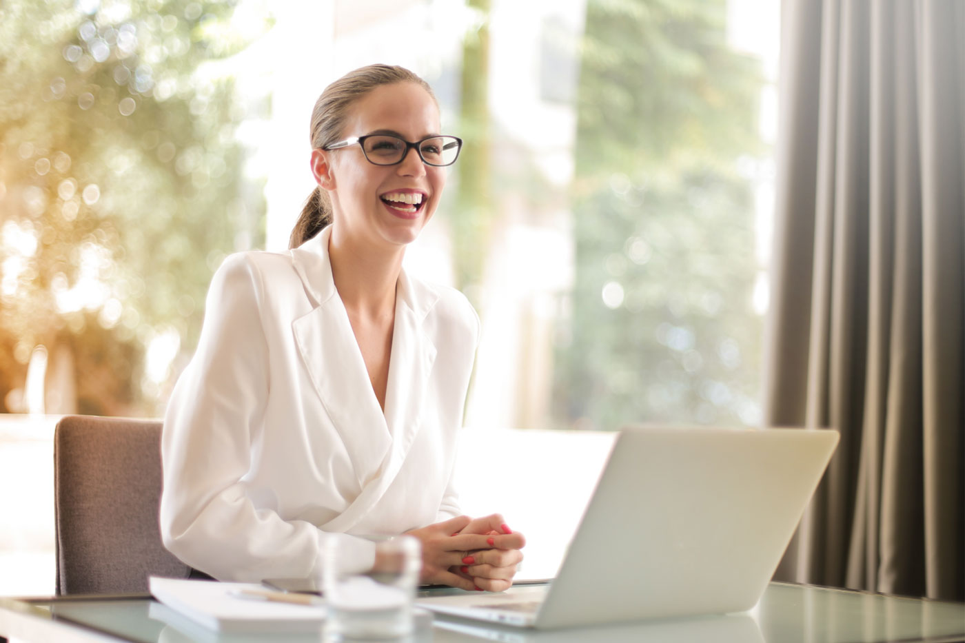 A smiling professional seated at a laptop